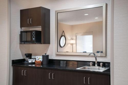 a kitchen with a sink and a mirror at Hampton Inn Loveland in Loveland