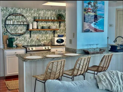 a kitchen with a counter with chairs around it at Oceanside Inn in Daytona Beach