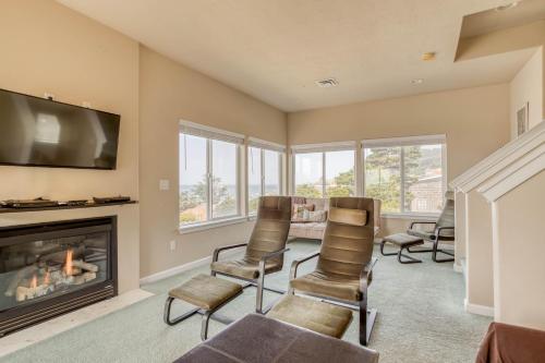 a living room with a fireplace and chairs at Oceana House in Lincoln City