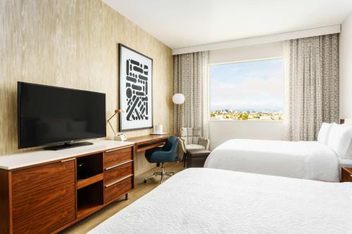 a hotel room with two beds and a flat screen tv at Hampton Inn & Suites Santa Monica in Los Angeles
