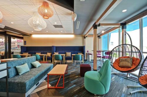 a lobby with a couch and chairs and tables at Tru By Hilton Chicopee Springfield in Chicopee