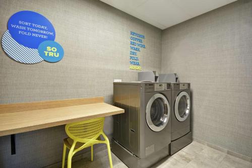 a laundry room with a washing machine and a counter at Tru By Hilton Chicopee Springfield in Chicopee