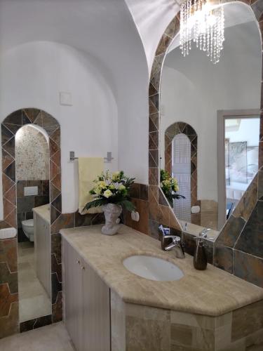 a bathroom with a sink and a mirror at Sherden - Esmeralda Luxury Apartment in Santa Marinella