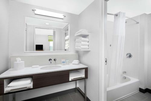 賽克斯頓的住宿－Hampton Inn Sikeston，白色的浴室设有水槽和淋浴。