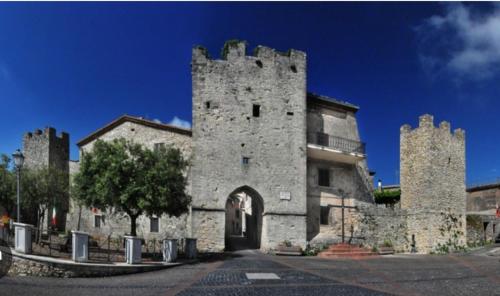ein altes Steingebäude mit einem Turm mit einem Eingang in der Unterkunft Giadahouse in Vico nel Lazio