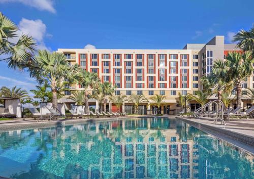 a hotel with a large swimming pool in front of a building at Hilton Miami Dadeland in South Miami