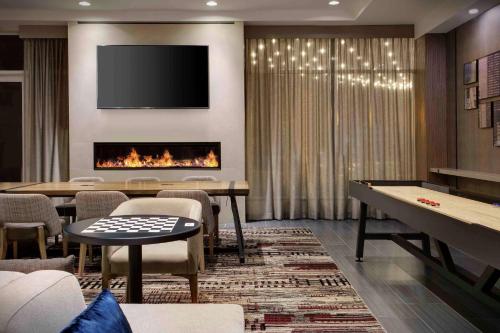 a living room with a fireplace and a table and chairs at DoubleTree by Hilton Chicago Midway Airport, IL in Bedford Park