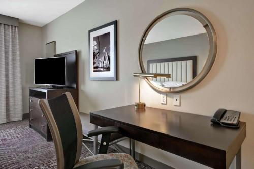 a hotel room with a desk and a mirror at DoubleTree by Hilton Chicago Midway Airport, IL in Bedford Park