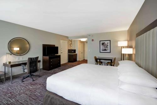 um quarto de hotel com uma grande cama branca e uma secretária em DoubleTree by Hilton Chicago Midway Airport, IL em Bedford Park