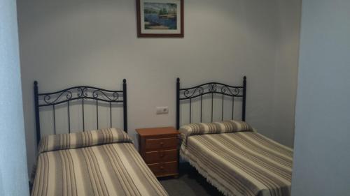 two beds sitting next to each other in a room at Hostal Cuesta de Belén in Arcos de la Frontera