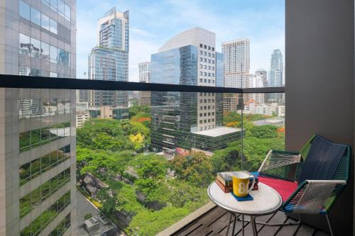 uma varanda com uma mesa e vista para a cidade em Hotel Indigo Bangkok Wireless Road, an IHG Hotel em Banguecoque