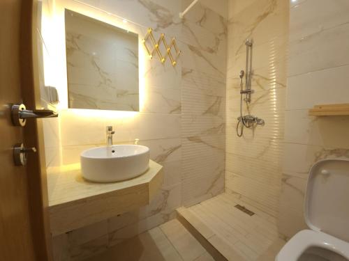 y baño blanco con lavabo y ducha. en Sidi Rahal Blue View, Piscine & mer sans vis-à-vis, en Sidi Rahal