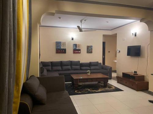 - un salon avec un canapé et une table dans l'établissement The Tropics Apartment Mombasa, à Mombasa