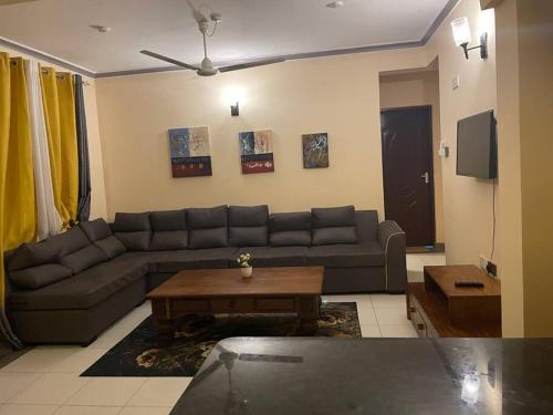 a living room with a couch and a table at The Tropics Apartment Mombasa in Mombasa