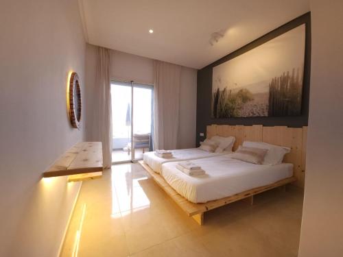 a bedroom with a large bed and a large painting on the wall at Sidi Rahal Blue View, Beachfront wide seaview with pool in Sidi Rahal