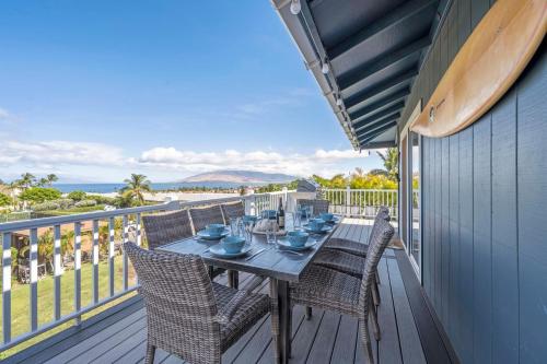 a dining table on a deck with a view of the ocean at Kauhale Breeze in Wailea