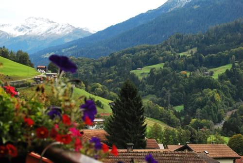 Blick auf ein Tal mit Bergen und Blumen in der Unterkunft Apartment with balcony and Panoramic Views of Alps in Klosters Serneus