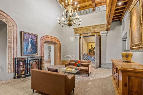 a living room with a couch and a chandelier at Quinta Real Puebla in Puebla