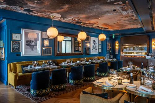 a restaurant with blue walls and tables and chairs at Hotel Montera Madrid, Curio Collection By Hilton in Madrid