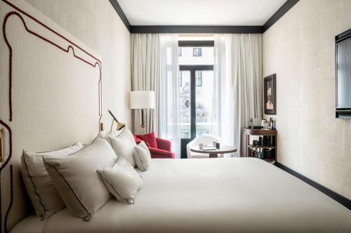 马德里Hotel Montera Madrid, Curio Collection By Hilton的卧室里有一张大床，配有白色枕头