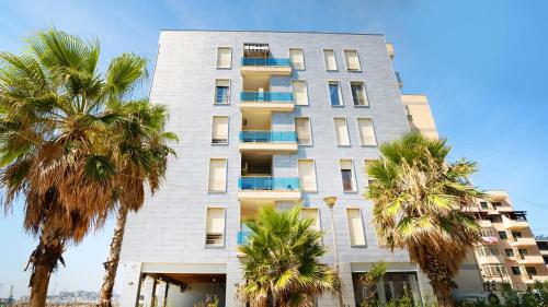 a tall building with palm trees in front of it at Sea view apartement in Durrës