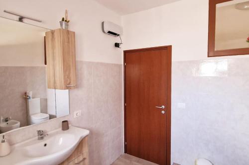uma casa de banho com um lavatório e uma porta de madeira em Casa Vacanze Margherita em Caltagirone