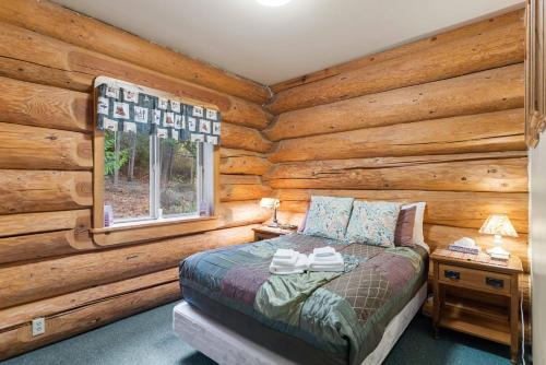 una camera con un letto in una baita di tronchi di Bear Ridge Cabin a Leavenworth