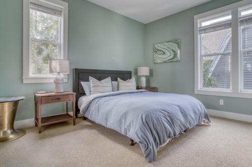 a bedroom with a large bed and two windows at Mertini in Depoe Bay