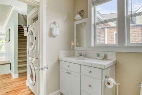 a white bathroom with a sink and a washing machine at Mertini in Depoe Bay