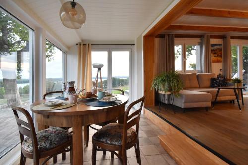a dining room with a table and chairs and a couch at Dadaj Park Home in Biskupiec