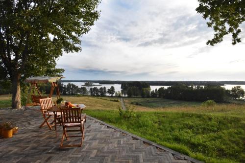 a table and chairs on a patio with a view at Dadaj Park Home in Biskupiec