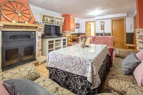 uma sala de estar com uma mesa e uma lareira em Amplio apartamento para corta o larga estancia em Cájar