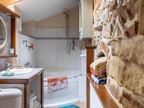 baño con aseo y pared de piedra en Stone country house in Rouy with private pool 