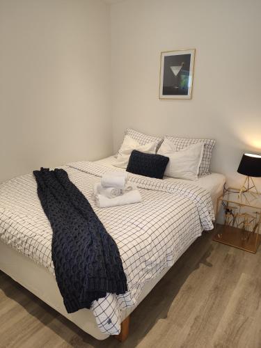 a bedroom with a bed with a black and white comforter at Göteborgs Pärla in Gothenburg