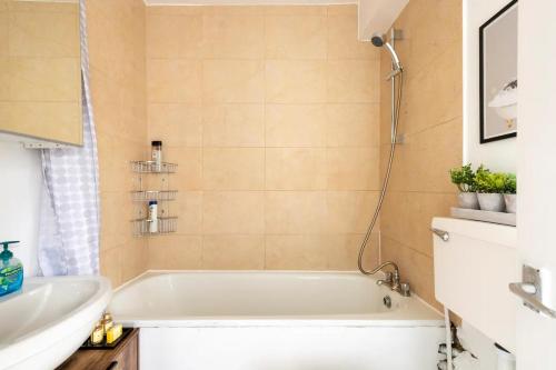 La salle de bains est pourvue d'une baignoire et d'un lavabo. dans l'établissement The Mayfield Apartment, à Londres