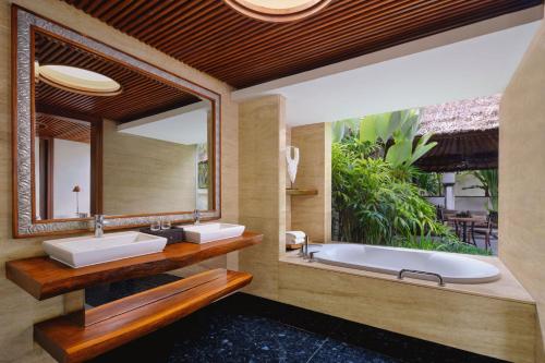 a bathroom with two sinks and a large mirror at Amarterra Villas Resort Bali Nusa Dua, Autograph Collection in Nusa Dua