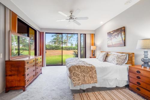 a bedroom with a bed and a dresser and a window at Waikoloa Fairways C120 in Waikoloa Village