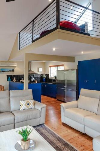 a living room with two couches and a kitchen at Tyrone Sands Rye in Rye