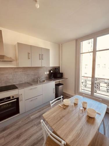une cuisine avec une table en bois et des chaises ainsi qu'une salle à manger dans l'établissement Studio de la Belle Vue, à Charleville-Mézières