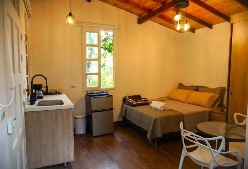 1 dormitorio con cama, lavabo y ventana en ENCANTO Minicasitas en medio de la naturaleza en Santa Elena