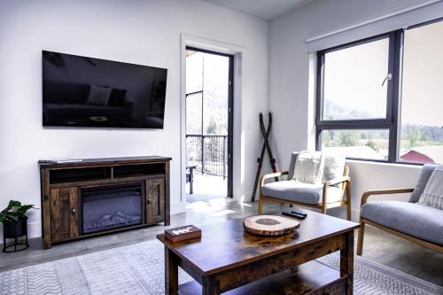 a living room with a fireplace and a tv at Revy's Stellar Retreat in Revelstoke