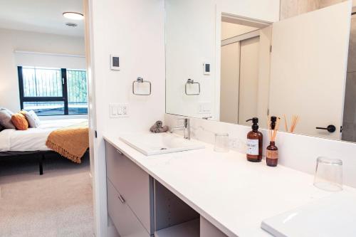 a white bathroom with two sinks and a mirror at Revy's Stellar Retreat in Revelstoke