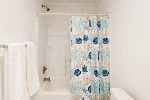 un bagno con tenda doccia e fiori blu di Long Lake House a Okeechobee