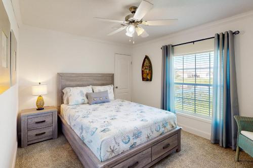 una camera con letto, ventilatore a soffitto e finestra di Long Lake House a Okeechobee