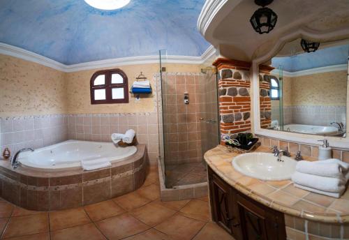 y baño con bañera, ducha y lavamanos. en Hotel Real Plaza, en Antigua Guatemala