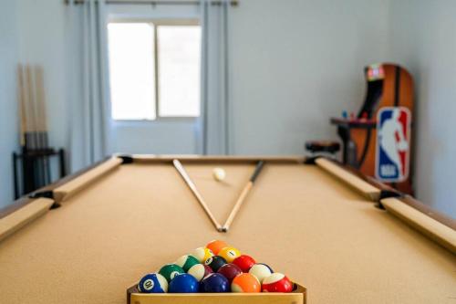 a pool table with cue balls in a room at Gilbert Getaway - pool+games+pool table in Gilbert