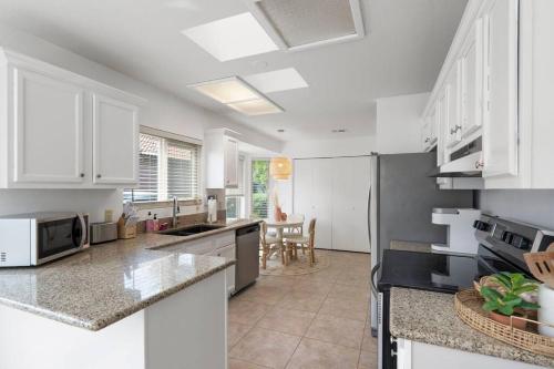 a kitchen with white cabinets and a counter top at Gilbert Getaway - pool+games+pool table in Gilbert