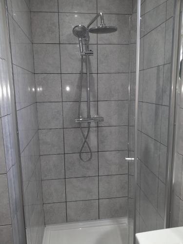 a bathroom with a shower with a shower head at MJ Serviced Apartment up to 6 Guest - Luxurious living in West London next to Tube station & Central London in Hanwell