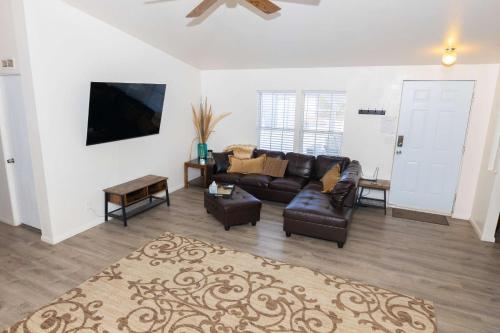 a living room with a couch and a tv at HERITAGE HOUSE GREAT FOR GROUPS!!! in Pahrump