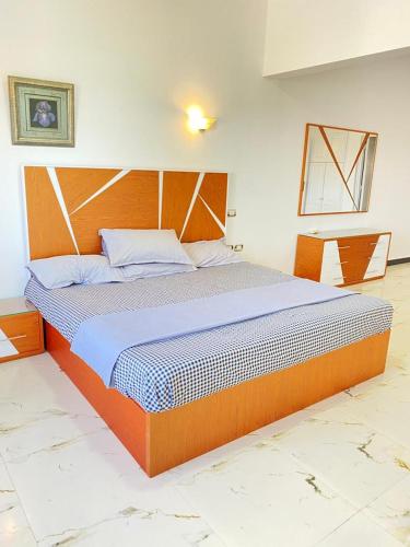 a bedroom with a large bed with a wooden headboard at فيلا للايجار مارينا 5 الساحل الشمالي in El Alamein